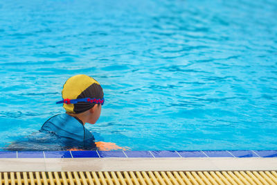 Boy swimming in blue pool