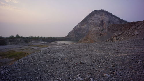 Rock formations on landscape against sky during sunset