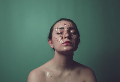 Close-up of woman with water and star shape decoration against green background