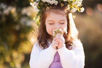 Cute girl smelling flowers