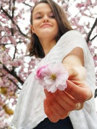 Portrait of woman with pink cherry blossom