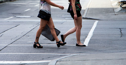 Low section of women walking on street