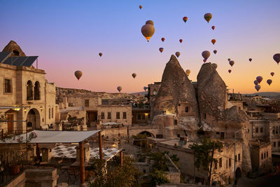 Hot air balloons flying over buildings in city