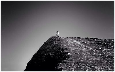 People on landscape against clear sky