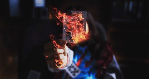 Digital composite image of woman holding burning card