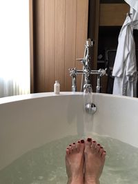 Low section of woman in bathtub