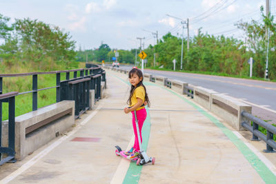 Portrait of young woman walking on road