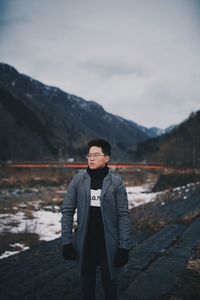 Portrait of man standing on mountain against sky