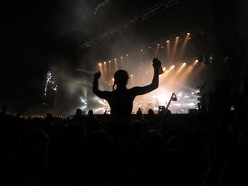 Silhouette people enjoying music concert at night