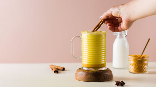 Banner with latte turmeric on a pink background. moon milk for better sleep. ayurvedic drink. 