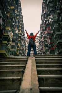 Rear view of woman standing against buildings