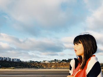 Portrait of girl looking away against sky