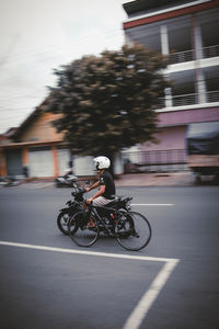 Man riding bicycle on road in city