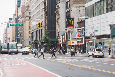 People walking on road along buildings