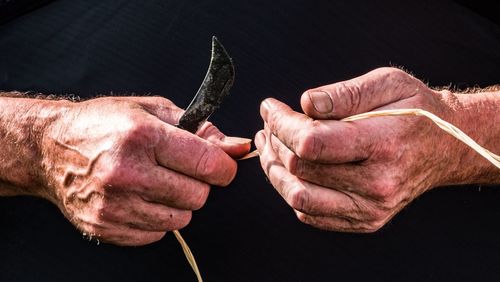 Midsection of man holding string and knife