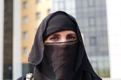 Muslim woman close-up portrait of her face black scarf on her head.