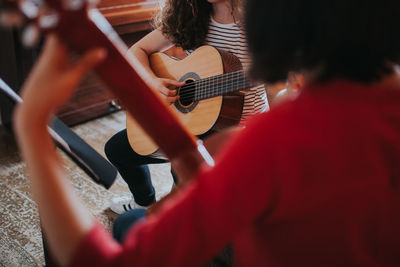Women playing guitar in music school
