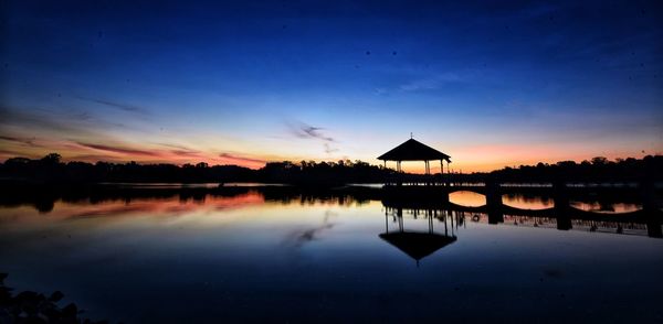 Silhouette built structure against sky at sunset