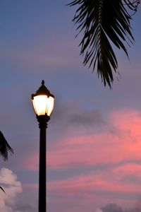 Low angle view of illuminated street light against sky at sunset