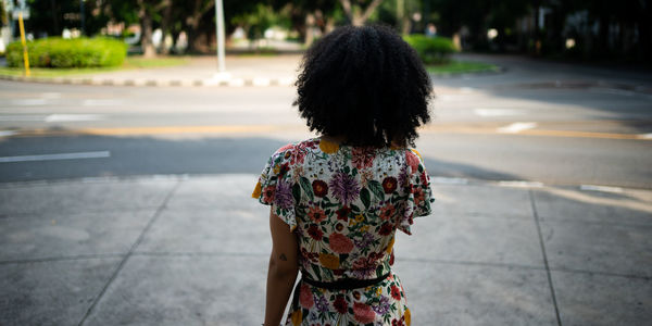 Rear view of woman standing on road