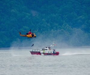 Helicopter above coast guard boat