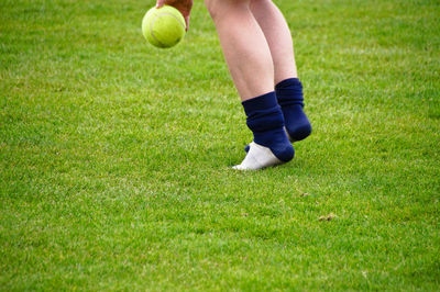 Low section of woman playing with ball on field
