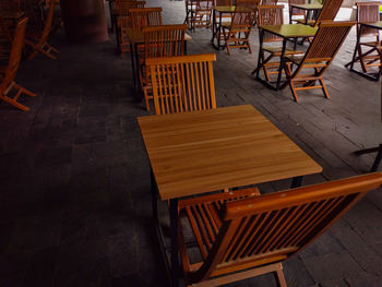 High angle view of empty chairs and tables at sidewalk cafe