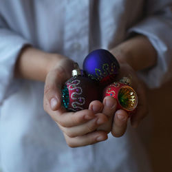 Close-up of hand holding multi colored christmas ornament