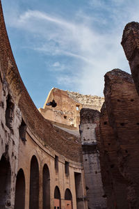 Low angle view of old ruin building against cloudy sky