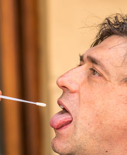 Close-up portrait of man holding cigarette