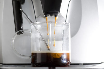 Close-up of coffee pouring in glass