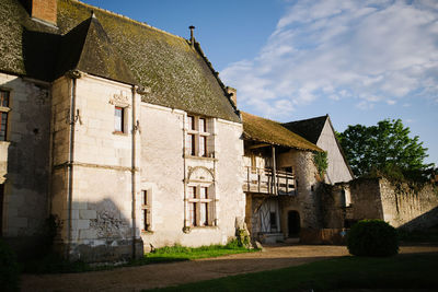 Exterior of old house by building against sky