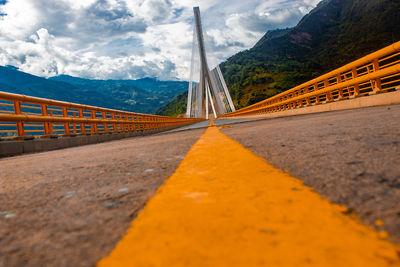 Surface level of road by bridge against sky