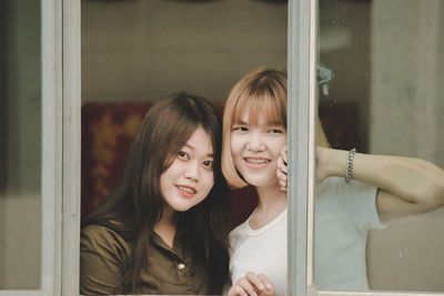 Portrait of smiling girl looking through window