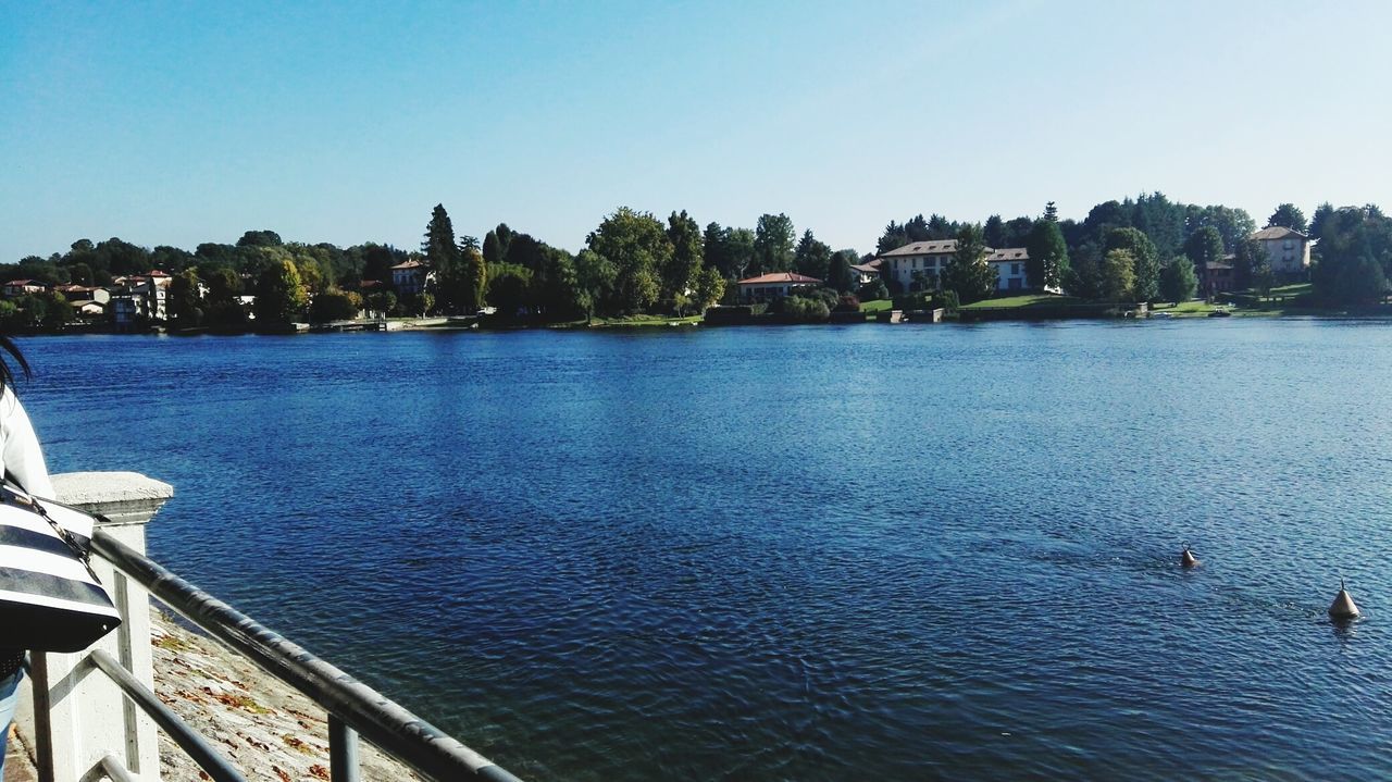 water, architecture, built structure, building exterior, clear sky, waterfront, river, copy space, city, rippled, blue, tree, sea, nature, bridge - man made structure, incidental people, outdoors, reflection, bird, lake