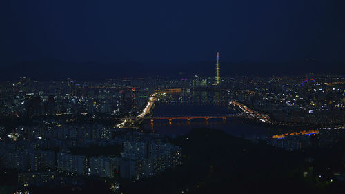 Aerial view of illuminated buildings in city at night