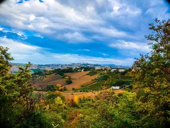 Scenic view of trees and buildings against sky