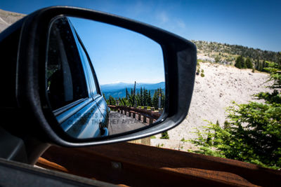 Reflection in side-view mirror of car 