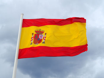 Low angle view of spanish flag against sky