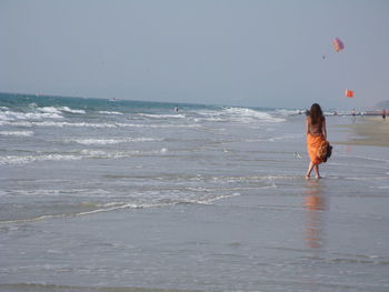 Woman on beach against sky