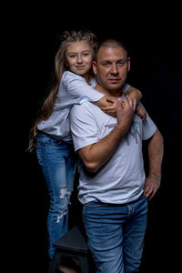 Portrait of a teenage girl against black background