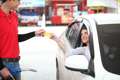 Woman with umbrella standing in car