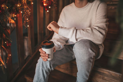 Portrait of candid authentic smiling handsome boy teenager using mobile phone at xmas home interior