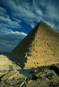 Historic pyramid against cloudy sky