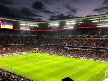 People on soccer field against sky at night