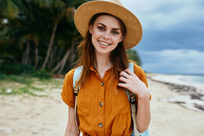 Portrait of smiling young woman standing on beach