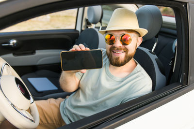 Young woman using mobile phone while sitting in car