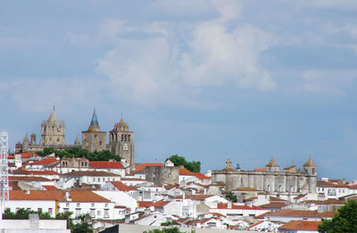 View of cityscape against cloudy sky