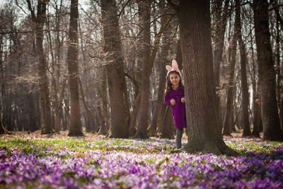 Portrait of woman with purple flowers in forest