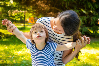 Portrait of mother and son playing in public park